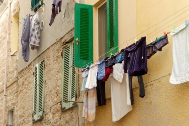 Eski Alghero, Sardinya, İtalya 'da kurulanmak üzere dışarıda asılı yeni yıkanmış eski giysiler. İtalyan şehrinin günlük hayatı. Klasik estetik..