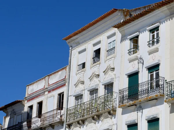 stock image Worn bright facades of white colour downtown at Praca do Giraldo square in Evora, Portugal.