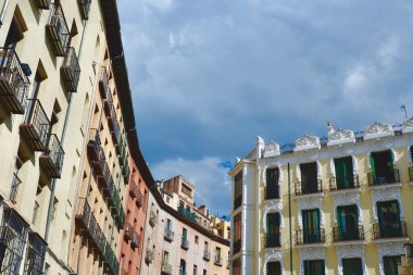 Madrid, İspanya 'da dramatik gri gökyüzü altında klasik cephelerde yükselen manzara.
