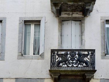 Fransa şehir merkezindeki farklı yumuşak renklerdeki konut binalarının eski moda otantik cepheleri. Klasik kepenkli pencereler ve balkon. Vintage mimarisi dışarıdan görünüyor.