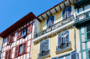 Bayonne şehir merkezinde, Bask Bölgesi, Fransa 'da renkli vintage cepheler. Farklı Fransız binalarında renkli panjurları olan pencereler.