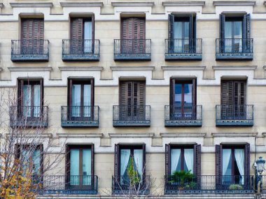 Madrid, İspanya 'nın merkezindeki Opera Bölgesi' nin klasik eski moda ön cephesinde panjurlu soluk camlar. Klasik İspanyol mimarisi.