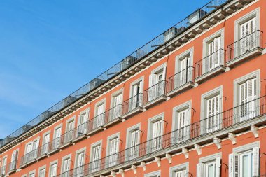 Madrid, İspanya şehir merkezinde bir çok penceresi olan renkli bir cephe. Klasik İspanyol mimarisi.