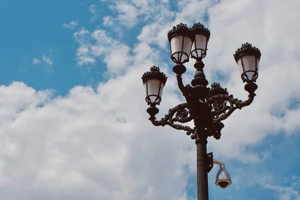 Vintage historical street lamp against moody skyline at daytime downtown Madrid, Spain.