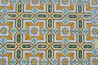 Lizbon, Portekiz 'deki yıpranmış eski püskü cephesinde geometrik süslemeli soluk sarı renkli seramik fayanslar..