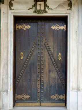 Zaragoza, İspanya 'da dekoratif elementlerle birlikte koyu kahverengi ahşaptan yapılmış eski bir kapı..