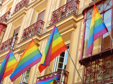 Vintage facades with vivid rainbow flags as a symbol of gay pride celebration in Chueca district, downtown Madrid, Spain. clipart