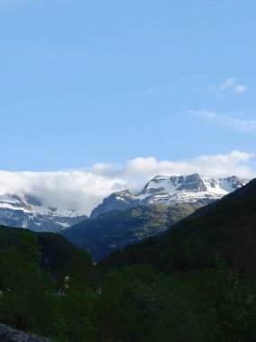 Dağlar karla kaplı İspanya 'daki yeşil tepelerin ardında.