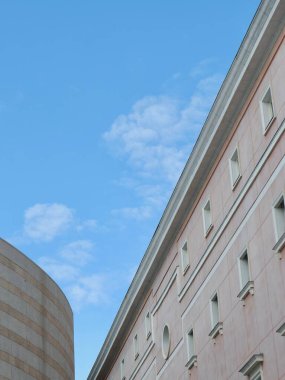 Birkaç bulutu olan parlak mavi gökyüzü eşsiz mimari yapıları tamamlıyor. Yapılarda çağdaş tasarım unsurları gösteren doku ve renklerin bir karışımı yer almaktadır..
