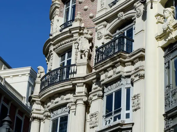 Tarihi mimari, bir bina üzerindeki süslü oymalar ve zarif balkonlarla vurgulanır. Açık mavi gökyüzü bu güzel şehir manzarasına canlılık katarak dikkatleri çekiyor. Madrid, İspanya