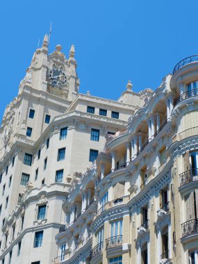 Bu çarpıcı bina, açık mavi gökyüzü altında klasik ve çağdaş mimarinin bir birleşimini sergiliyor. Dış görünüşün karmaşık ayrıntıları tasarımın sanatsallığını yansıtır. Yakınlarda, hareketli şehir hayatı yayalar ve canlı mağazalarla aydınlanıyor.