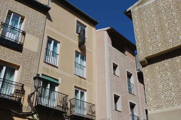 Canlı binalar tarihi bir alanda karmaşık tasarımlar ve balkonlar sergiliyor. Güneş ışığı dokuyu ve desenleri aydınlatır ve sıcak bir atmosfer yaratır..