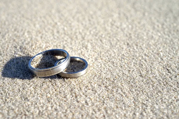 コピースペースがたくさんある風の強い日のビーチでの結婚指輪 — ストック写真