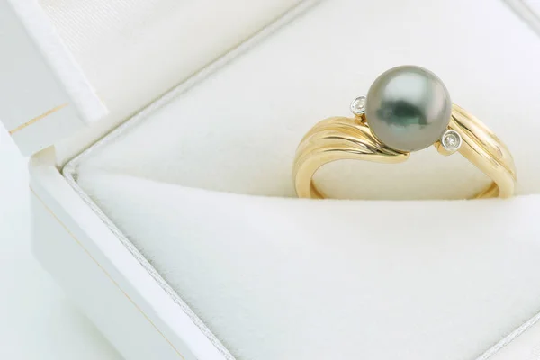 白色首饰盒内饰有灰色珍珠的金戒指关门 — 图库照片