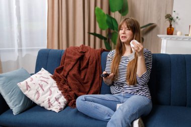 Kanepede oturan, melodram seyreden ve ağlayan güzel genç bir kadın.