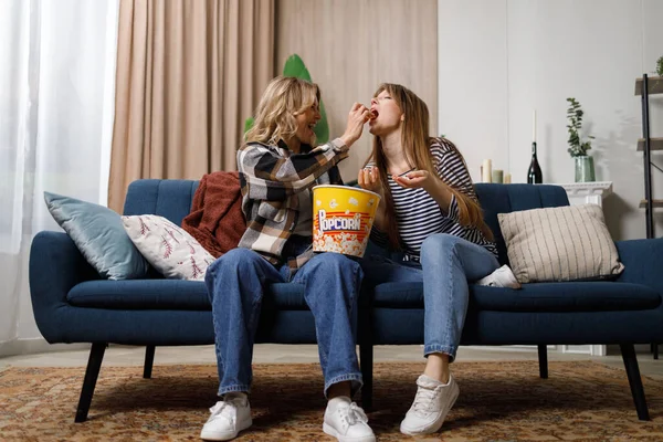 Stock image Two women of different ages hanging out together and sharing popcorn