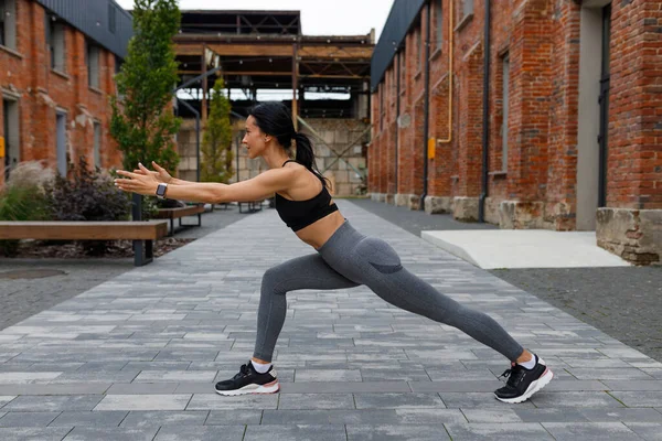 stock image Slim sporty woman stretching in yoga pose outdoors