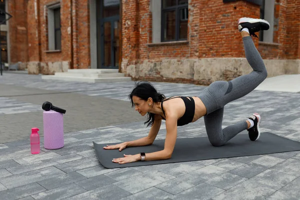 Spor Kıyafetli Kadın Dışarıda Yoga Minderinde Bacak Yükselterek Eşek Tekmesi — Stok fotoğraf