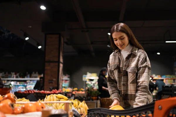 Mujer Pone Plátanos Carro Mientras Compra Una Tienda Comestibles — Foto de Stock