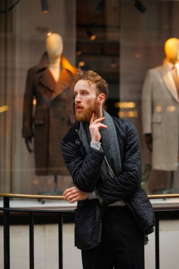 Zarif bir giyim mağazasının arka planında şık sakallı bir adamın portresi