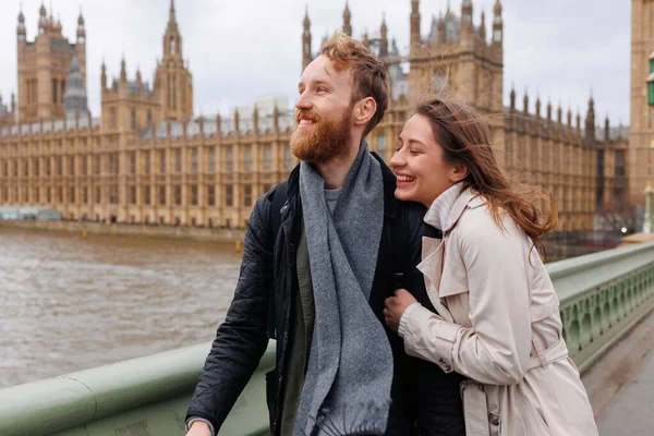 stock image Happy young couple walks holding hands against the background of London's Big Ben