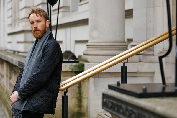 stock image Bearded hipster leans against a railing in the middle of a London street