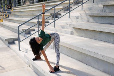 Atletik genç kadın geriniyor.