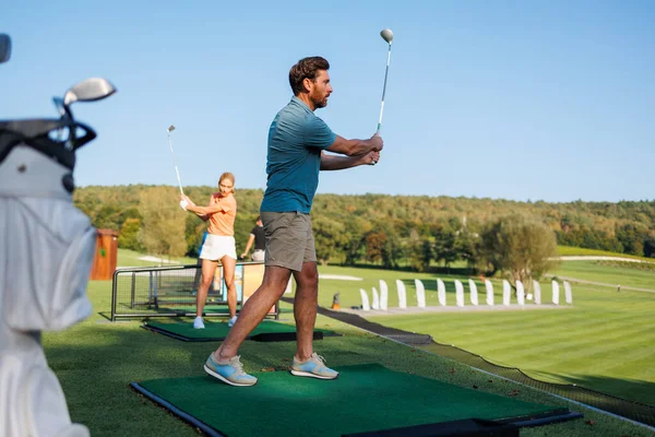 Golfing Harmony: Youthful Couple on Course