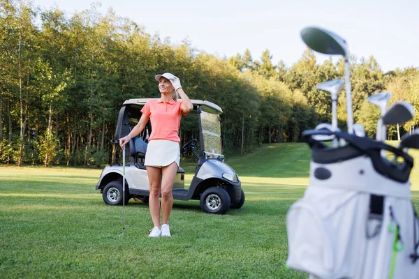 Woman Golfer with Cart and Club in Hand