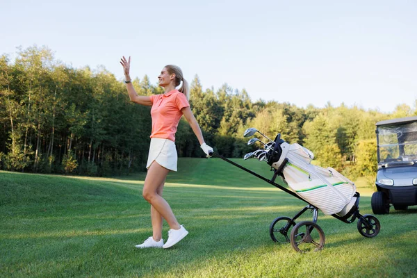 Golf sahasında güneşli bir gün: Golf ekipmanlı bir kadın