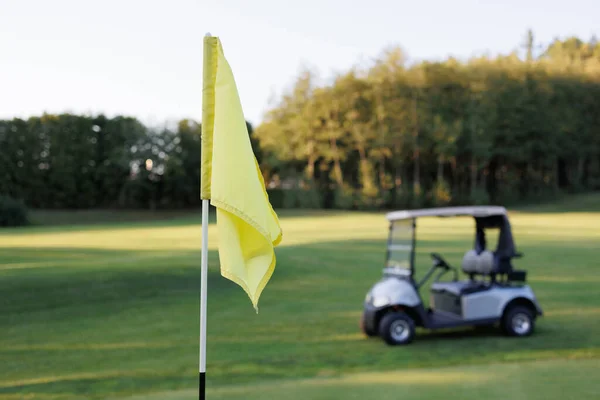 Closing Moments on the Course: Golf Cart and Flag