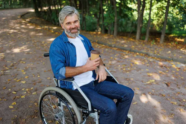 Inclusive Leisure: Person in Wheelchair Enjoying Coffee Amidst Nature