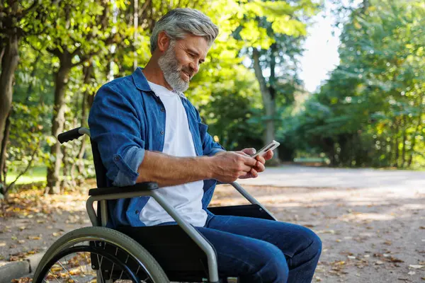Obejmująca Dostępność Mężczyzna Wózku Inwalidzkim Komunikujący Się Parku — Zdjęcie stockowe