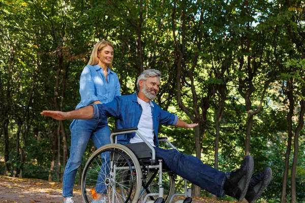 Kobieta Pomaga Zamaskowanemu Mężczyźnie Wózku Inwalidzkim Navigate Park — Zdjęcie stockowe