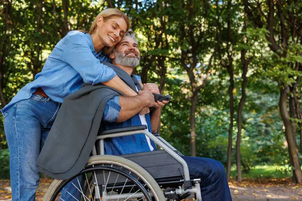 Pielęgnacja Kobieta Zapewnia Komfort Dla Mężczyzny Wózku Inwalidzkim — Zdjęcie stockowe