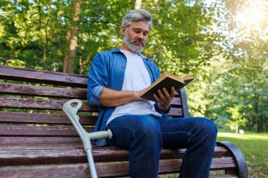 Okuyucuları Güçlendiren: Park 'ta Koltuk değnekli Kararlı Adam Okumada Özümsendi
