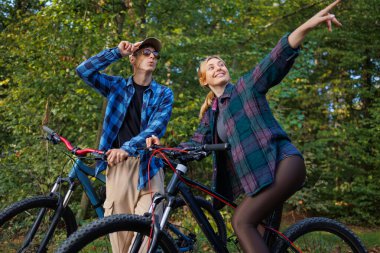 Bisiklet sürerken çevredeki doğaya bakan çiftler.