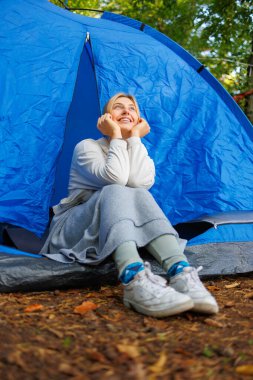 Hayalperest genç bir kadın ormandaki bir çadırda oturuyor.