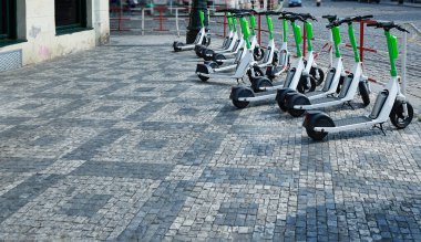 Yeşil elektrikli mobiletler gün boyunca sokakta durur. Şehirde elektrik taşımacılığı.