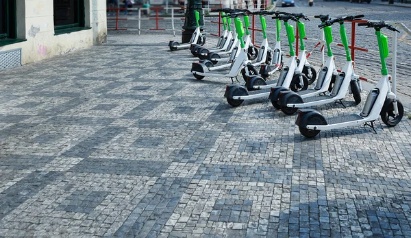 green electric scooters stand on  street during day. Electric transport in the city.