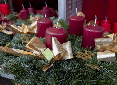 Dört kırmızı mum ve altın kurdeleli tam kare Advent çelengi. Mum ile Noel süslemesi