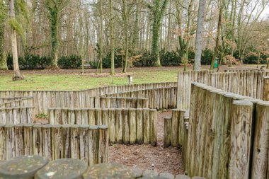 Bir bahar günü çimenlikteki ağaçların arasındaki ahşap labirentin genel manzarası