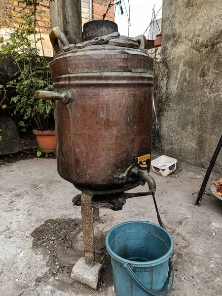 stock image Stock photo of old rusty copper water heater, old method used for heating water for bath kept at backyard of the house. Picture captured early in the morning at Kolhapur, maharashtra, India.