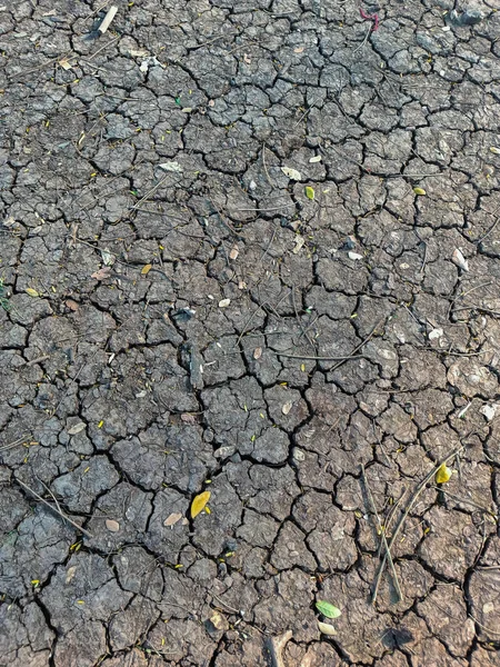 Stock photo of dry and cracked soil surface of ground,Picture captured during drought in the Indian rural area. lack of rainfall, water shortage, excess water demand, global warming causes of drought.