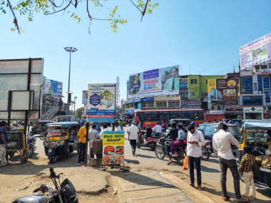 Gulbarga, India- january 18th 2023; Stock photo of crowded market area, vehicles stuck in the traffic, people moving ,waiting for public transport. commercial buildings, hording board on background.