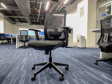 Hyderabad, India- 23 Aralık 2022; Arkaplanda bir bilgisayar masası ve diğer iç mekan eşliğinde siyah-sırt sırtı ergonomik bir masa başı metal tabanının stok fotoğrafı.