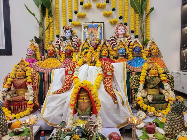 Güzel süslenmiş Lord Ganesha ve Lakshmi putlarıyla dolu, canlı çiçekler, lambalar ve geleneksel şenlik düzenlemeleri ile süslenmiş bir Güney Hindistan evinde ev yapımı pooja..