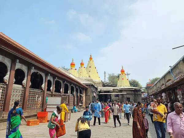 Kolhapur, Hindistan 7 Kasım 2023 Kolhapur Ambabai Tapınağı açık mavi gökyüzü altında dindarlarla dolup taşıyor. Canlı tapınak kuleleri, geleneksel mimari, işlek bir avlu kültürel özünü yakalamak..