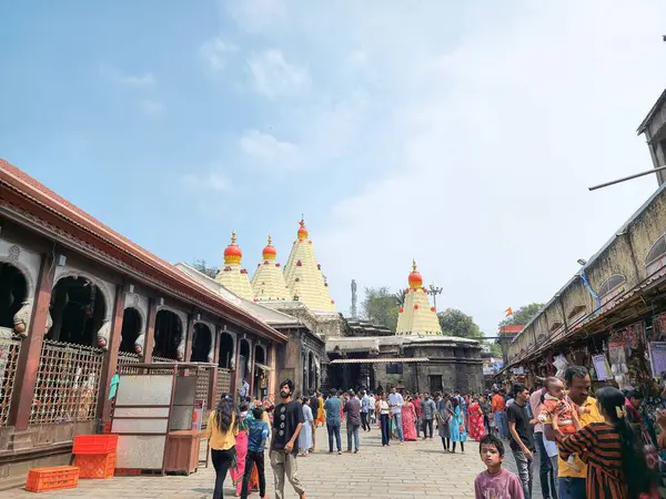 Kolhapur, Hindistan 7 Kasım 2023 Kolhapur Ambabai Tapınağı açık mavi gökyüzü altında dindarlarla dolup taşıyor. Canlı tapınak kuleleri, geleneksel mimari, işlek bir avlu kültürel özünü yakalamak..