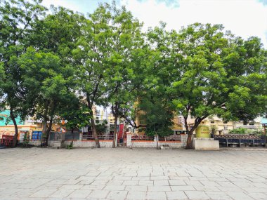 Gulbarga, Hindistan, 8 Ağustos 2023; Hindistan 'da bir Hindu tapınağının geniş, taşlarla döşenmiş avlusu huzurlu, açık bir alan sunuyor. Yapraksı yeşil ağaçlar, kutsal binaları gösteren gölgeler sağlar.